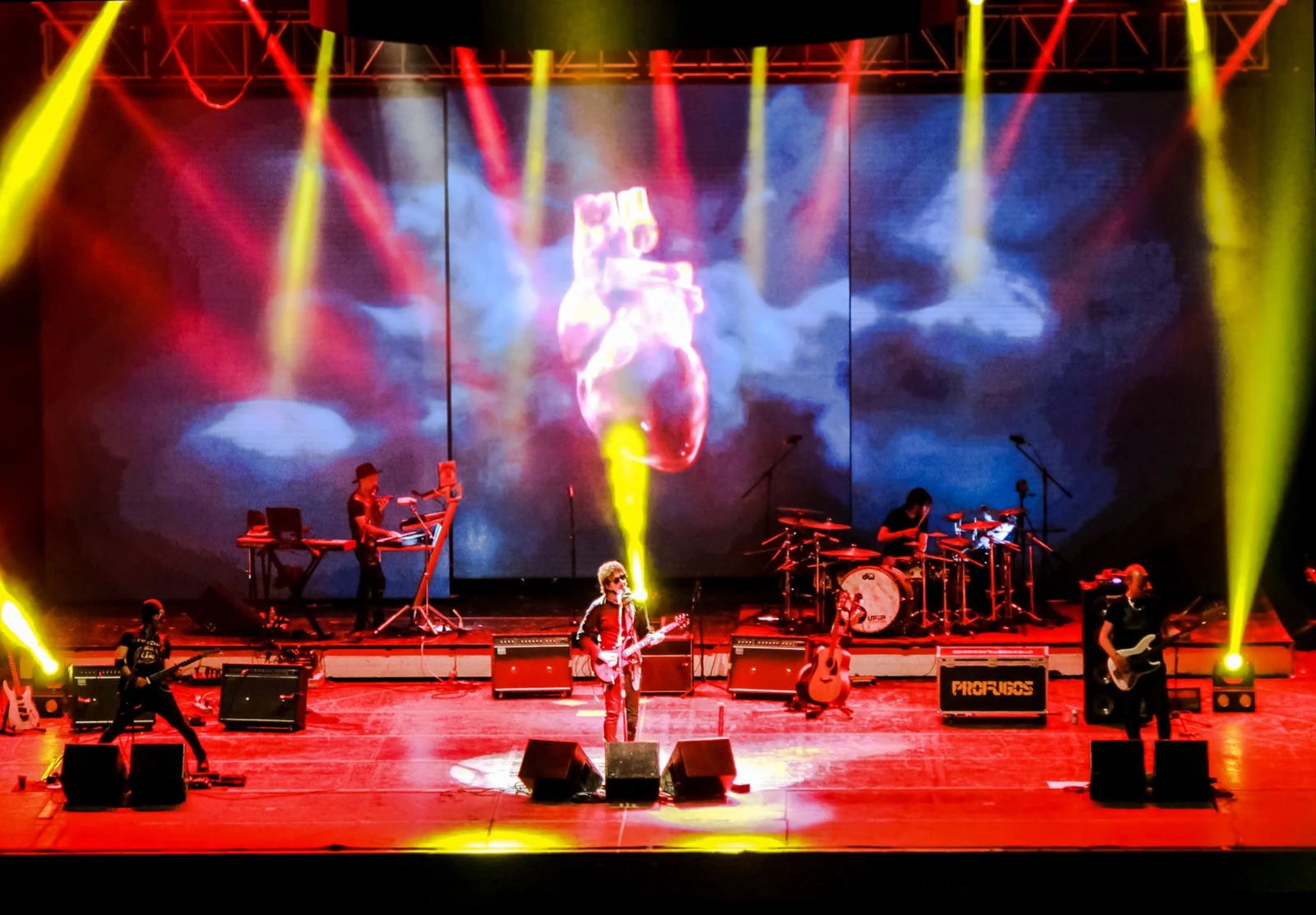 PROFUGOS en un gran escenario con visuales y luces rojas y amarillas